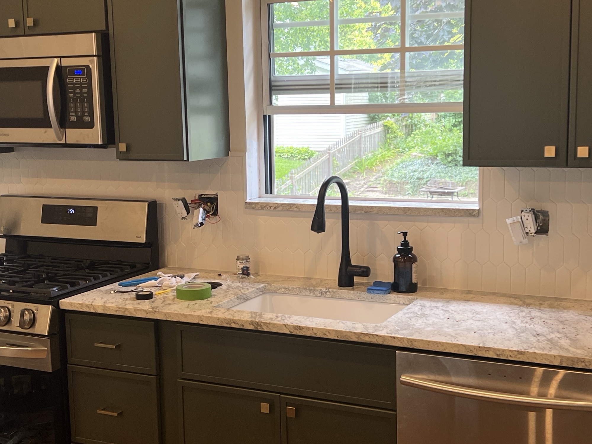 Green kitchen window black faucet